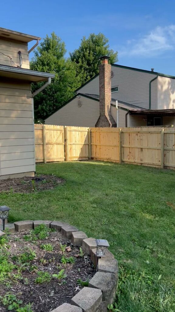 A complete wood fence installation enclosing a backyard, featuring a gate, by ReliableFencing in Columbus, OH.