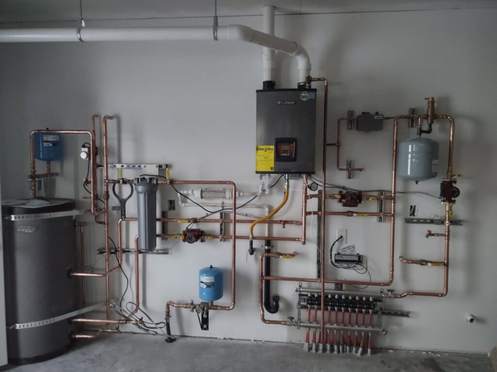 A complete heating system with boiler, water heater, and radiant manifolds by Boiler Man Plumbing & Heating in Palmer, AK