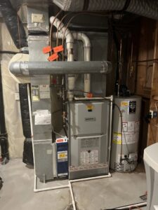 A complete HVAC system, including a furnace, water heater, and ductwork, installed in a basement by Bloomington Heating & Air in Bloomington, MN.