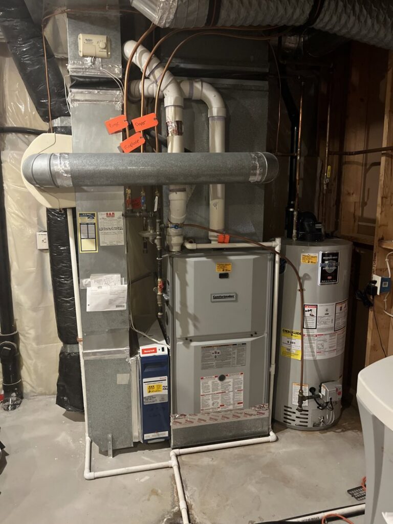 A complete HVAC system, including a furnace, water heater, and ductwork, installed in a basement by Bloomington Heating & Air in Bloomington, MN.