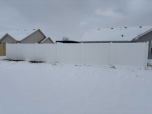 A complete white vinyl fence project enclosing a large residential yard, installed by H&M Fencing LLC in Decatur, IN.
