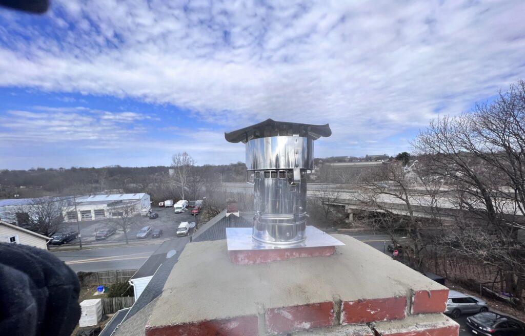 A newly installed stainless steel chimney cap on a brick chimney, a completed job by Maximum Energy Savers in Philadelphia, PA