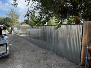A completed corrugated metal fence installation with a work truck nearby by Tomahawk Fencing in Riverton, WY.