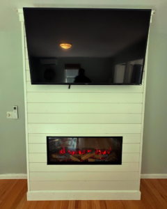 A completed electric fireplace and TV installation by Greer Enterprises in Raymond, NH.