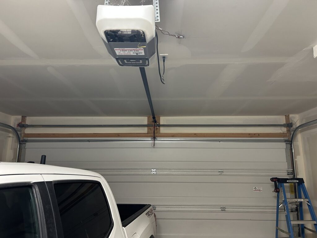 A newly installed white garage door and opener system, completed by SS Garage Door Repair in Denver, CO.