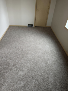 Completed grey carpet installation in a room by La 23 floors an more in Janesville, WI.