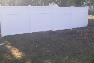 A completed section of a white vinyl privacy fence installed by D & G'S Maintenance LLC in Woonsocket, RI.