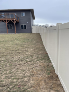 A newly completed white vinyl fence with a gate installed by Flash Fence for a backyard in Phenix City, AL.