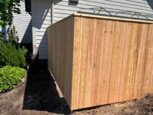 A completed wood fence section installed next to a residential building by RL Quality construction in Gaston, OR.
