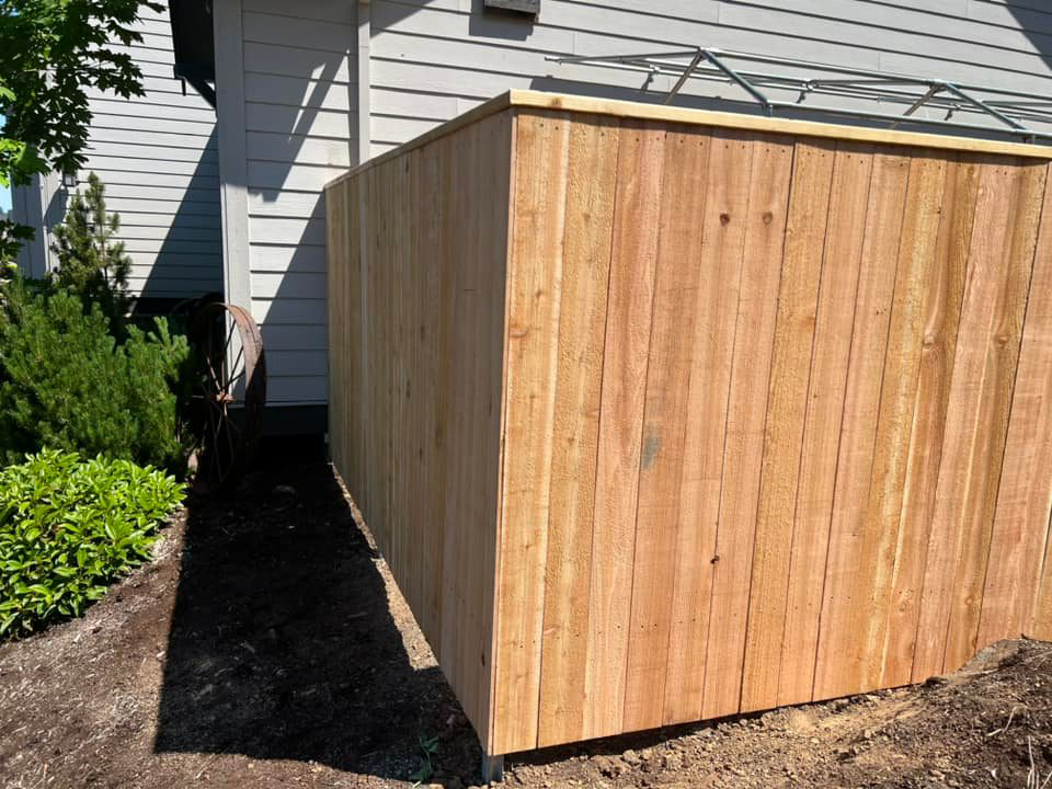 A completed wood fence section installed next to a residential building by RL Quality construction in Gaston, OR.