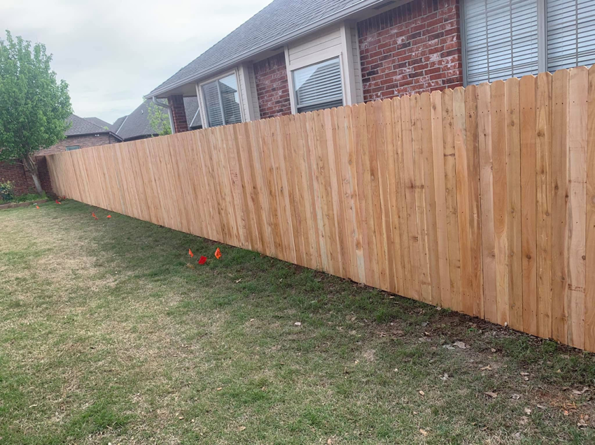 A beautiful, newly completed wood privacy fence enclosing a backyard, built by Fence Innovations in Norman, OK.