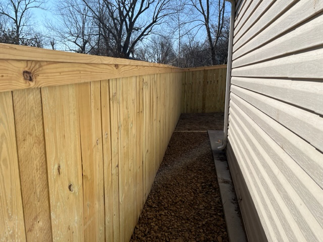 A completed wood privacy fence corner installed by Fence Solutions of NWA in Gravette, AR.