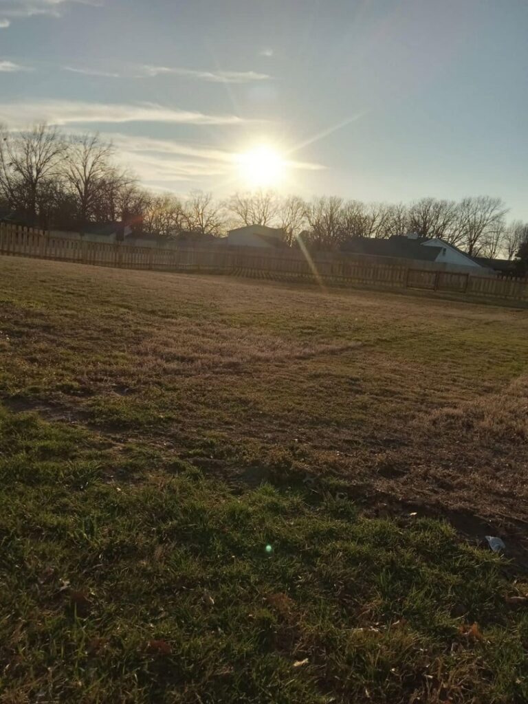 A long completed wooden picket fence stretching across a field, installed by Fianna Fencing Company in Fort Smith, AR.
