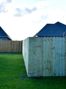 A newly completed wooden privacy fence section in a residential backyard by Gator Fence Co. in Miami, FL
