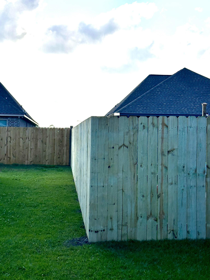 A newly completed wooden privacy fence section in a residential backyard by Gator Fence Co. in Miami, FL