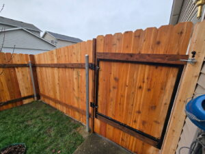 A newly completed wooden privacy fence with a gate, expertly installed by Fence Repair Master in Vancouver, WA.