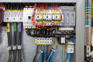 A detailed view of a complex electrical panel with neatly organized wiring and components, showcasing expert installation by Devaney Electric Co. in Lacey, WA.