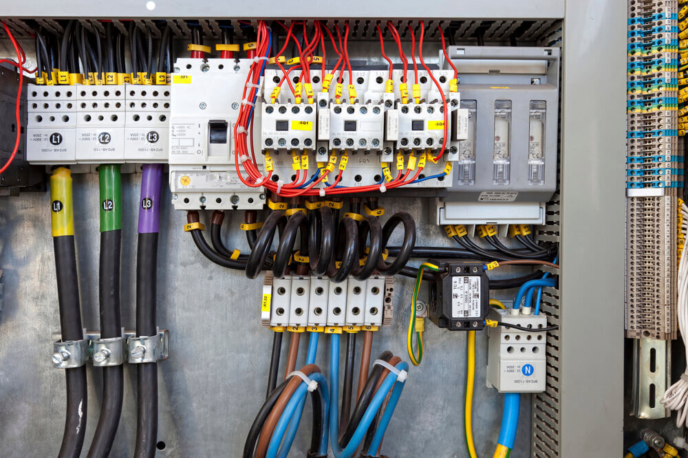 A detailed view of a complex electrical panel with neatly organized wiring and components, showcasing expert installation by Devaney Electric Co. in Lacey, WA.