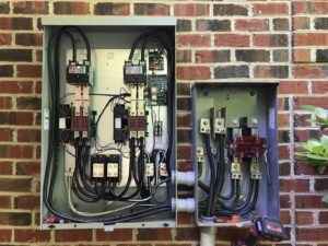 Complex exterior electrical panels with intricate wiring and components installed by Volt Doctors in Durham, NC