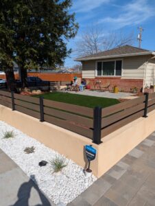 A modern composite horizontal fence with black metal posts by Jaz Builders Inc in Santa Clara, CA.