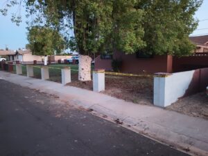 Concrete pillars and a low wall fence under construction with caution tape by Arce Masonry LLC in Glendale, AZ