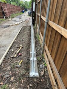 A concrete trench with metal rails for a sliding gate installation by HDR Systems Gate, Fence & Garage doors in Plano, TX