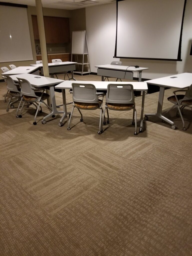 A conference room with newly installed patterned carpet tiles by Heather Mountain Flooring in Layton, UT.