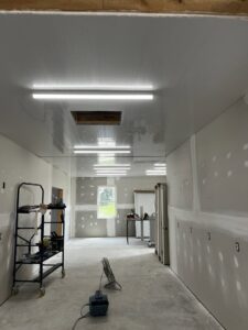 Fluorescent strip lights installed on the ceiling of a room during the construction phase, a service provided by Superior Electrical Solutions llc in Clear Spring, MD.