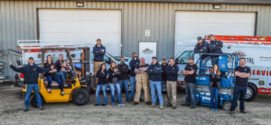 The team of Continental Door Company standing with their service trucks and equipment in Spokane Valley, WA.