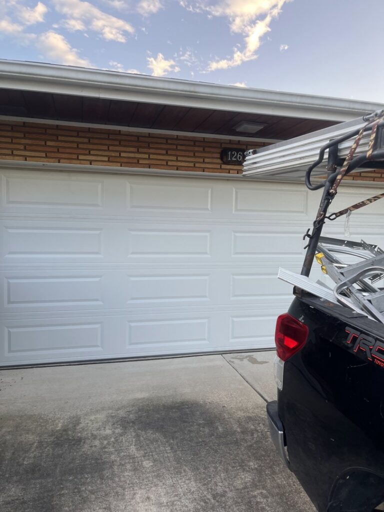 A contractor's truck with ladders parked at a garage door job site by The Region's Garage Door Repair in Hammond, IN.
