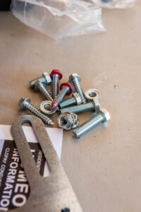 A smiling garage door contractor working on the tracks and panels of a garage door for Annapolis Garage Doors Inc. in Annapolis, MD.