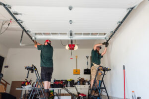 Two garage door contractors installing the top section of a garage door and opener for Annapolis Garage Doors Inc. in Annapolis, MD.