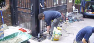 Contractors installing a new metal gate at a residential property for Royal Garage Door Services in Boston, MA