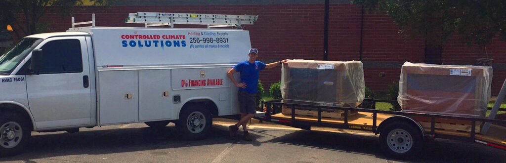 A Controlled Climate Solutions service truck with a technician and new HVAC units on a trailer in Decatur, AL.