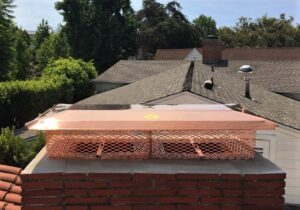 A newly installed copper chimney cap on a brick chimney by The Chimney Guy in Los Angeles, CA.
