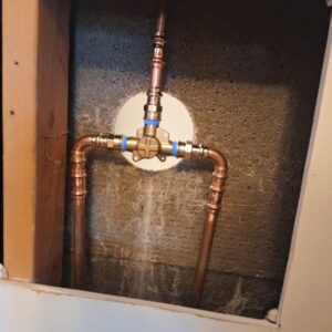 Copper pipes connected to a heating manifold or mixing valve installed by Neal Harris Service Experts in Overland Park, KS.