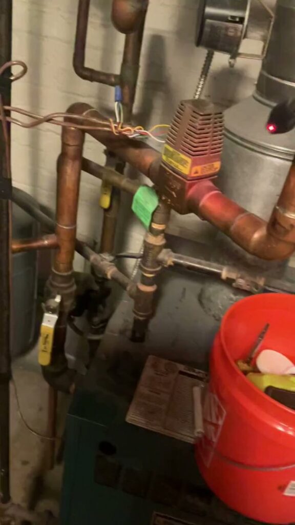 Close-up view of copper pipes and valves, part of a heating or plumbing system, serviced by Markool Heating Cooling Plumbing in Frederick, MD.