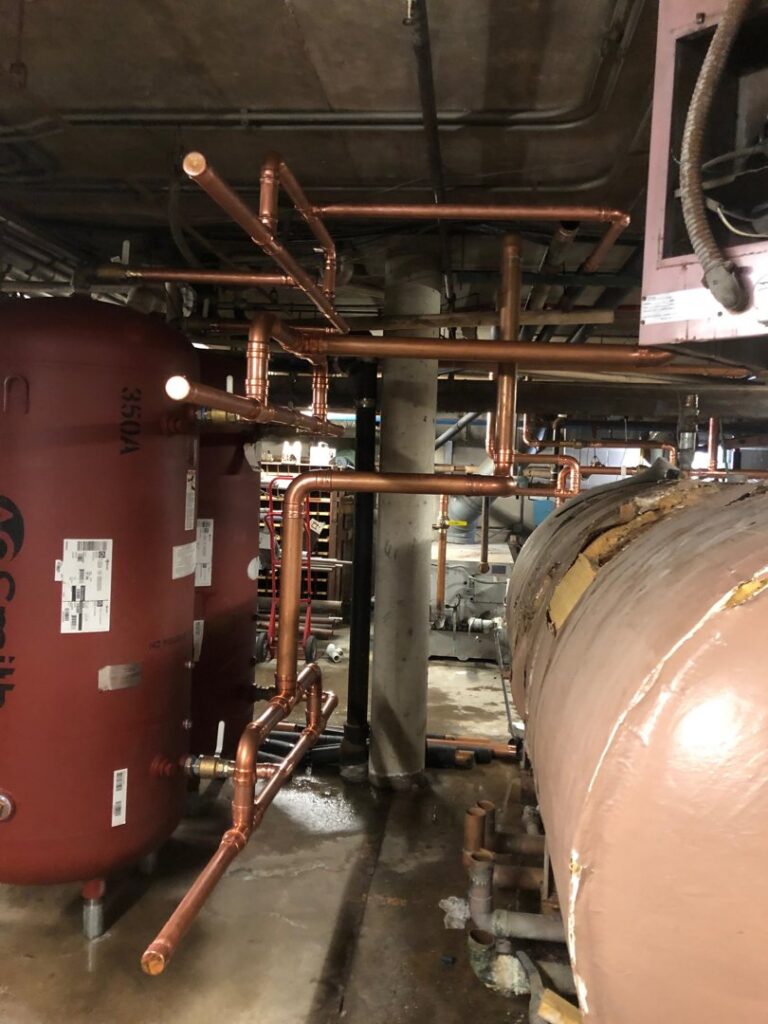 Extensive copper piping installation in a mechanical room, showcasing work by R.J. O'Neil Inc. in Montgomery, IL.