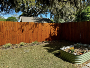A corner view of a backyard with a wooden privacy fence installed by Barwick Fence Company in Savannah, GA.
