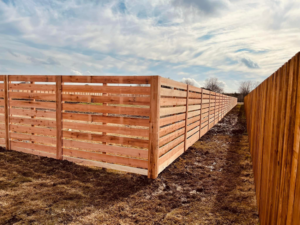 Corner section of a newly installed horizontal wood slat fence by Plano Fence and Arbor Pro in Plano, TX.