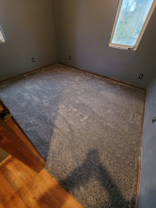 A corner room featuring new grey carpet flooring installed by Washington Family Flooring LLC in Bellevue, NE.