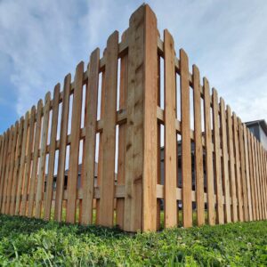 A low-angle view of a sturdy corner of a wood picket fence by Hotshot Fencing and Gates in Kansas City, MO.
