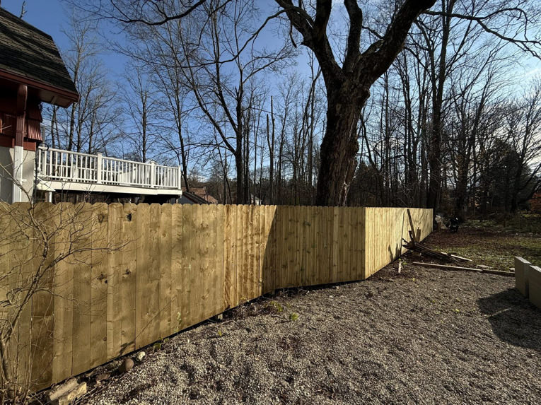 A corner section of a sturdy wood privacy fence installed by Red Lake Fencing & Construction for a property in Springfield, MA.