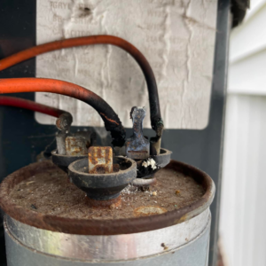 A corroded AC capacitor needing repair, serviced by Wilson Heating & Cooling, Inc. in North Chicago, IL.
