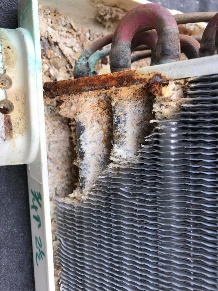 Close-up of corroded and damaged HVAC coil fins, indicating a need for repair from Bergmann Heating & Air Conditioning, LLC in Orem, UT