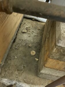 A close-up of a corroded and dirty floor area next to an HVAC system, indicating a problem addressed by Coe Heating & Air Conditioning in Fort Wayne, IN.