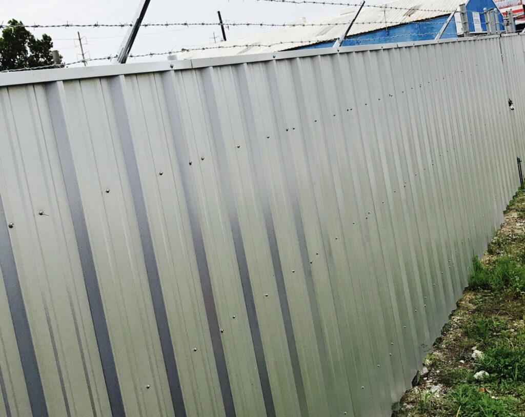 A corrugated metal fence with barbed wire installed by Amko Fence Co. in Kenner, LA.