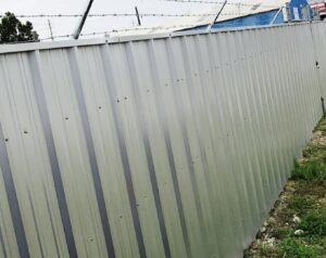 A corrugated metal fence with barbed wire installed by Amko Fence Co. in Kenner, LA.