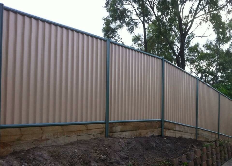 A corrugated metal privacy fence installed on a sloped terrain by Fence Company Chicago in Chicago, IL