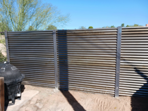 A newly installed corrugated metal privacy fence in a backyard by Gotta Have It Fence in Tucson, AZ.